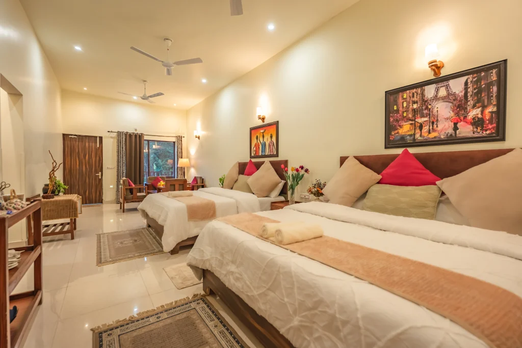 Spacious double deluxe room at Pristine Woods, The Best Resort in Dehradun, featuring two comfortable king-size beds, elegant décor, warm ambient lighting, modern amenities and a serene layout ideal for families and group travellers.