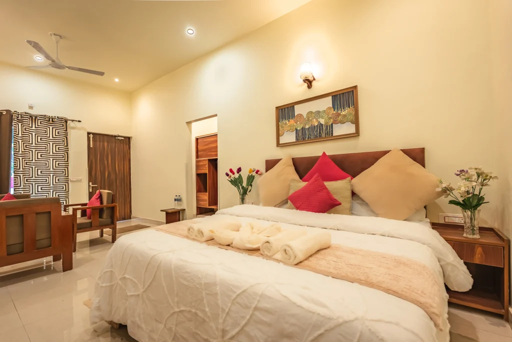 Luxury deluxe room at Pristine Woods, the Best Resort in Dehradun, featuring a plush king-size bed, elegant wooden interiors, soft ambient lighting and premium furnishings for a refined and relaxing stay.