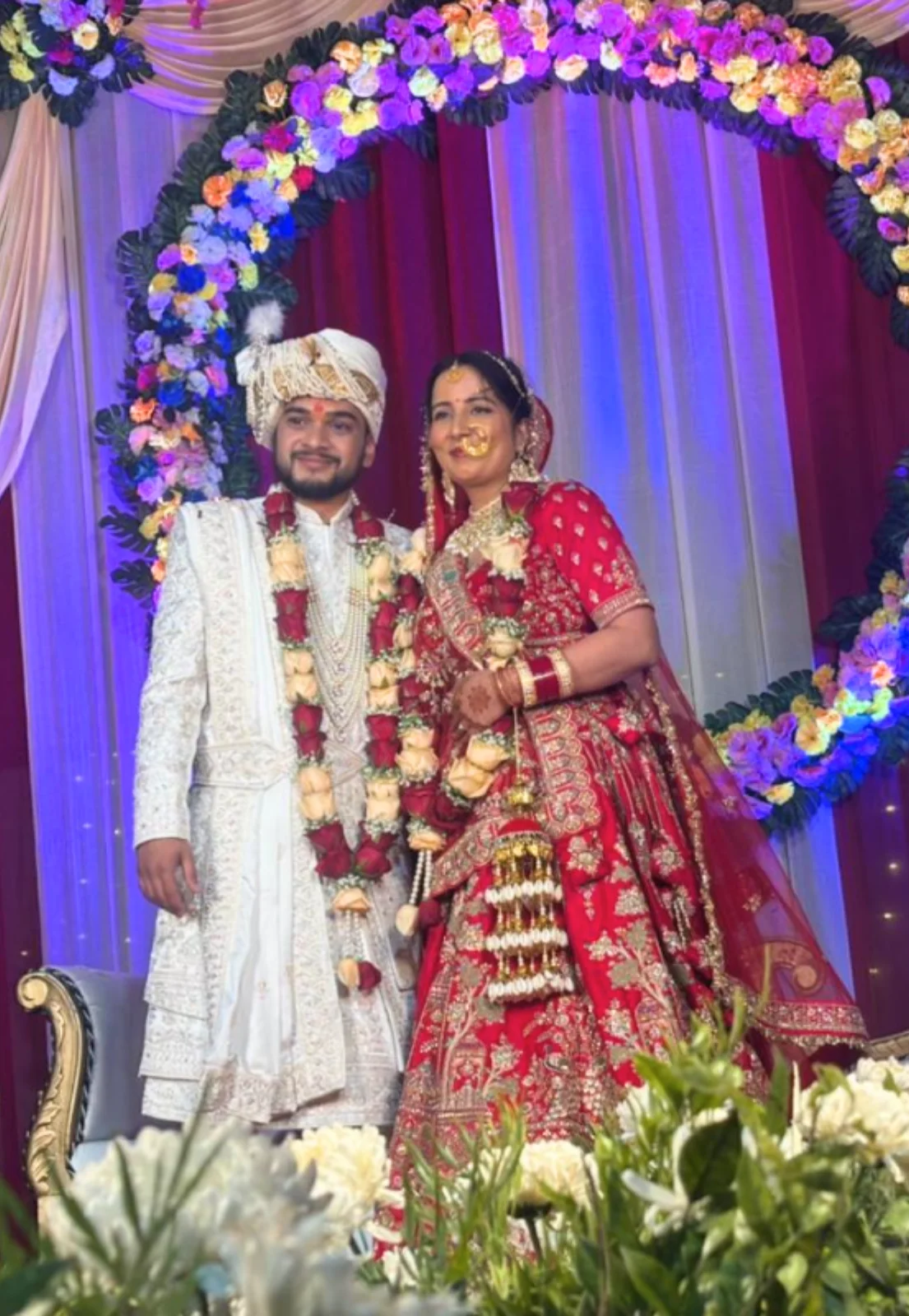 Bride and groom celebrating a beautiful destination wedding in Dehradun at Pristine Woods Resort with floral mandap and grand stage decor