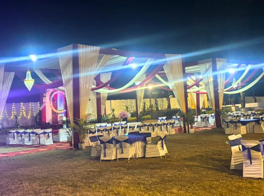 Spacious outdoor wedding venue in Dehradun featuring decorated lawn, canopy stage and illuminated resort building
