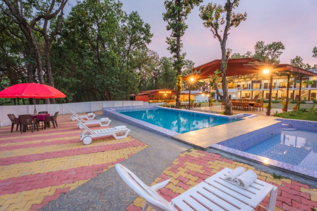 Best resort in Dehradun with swimming pool, poolside seating and forest view at Pristine Woods